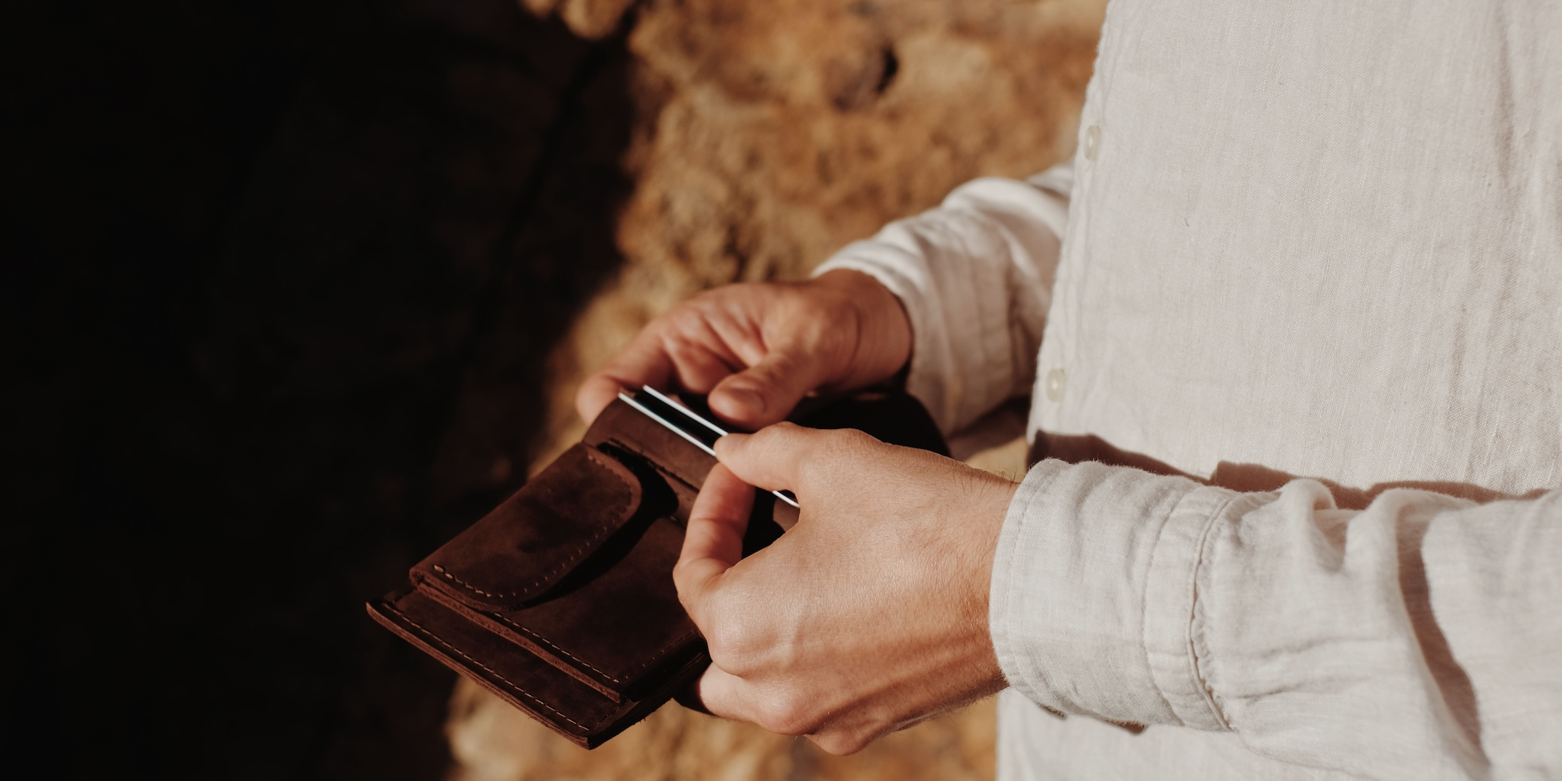 Man using his wallet from the 99things Swiss online shop Men's Small Leather Goods collection.