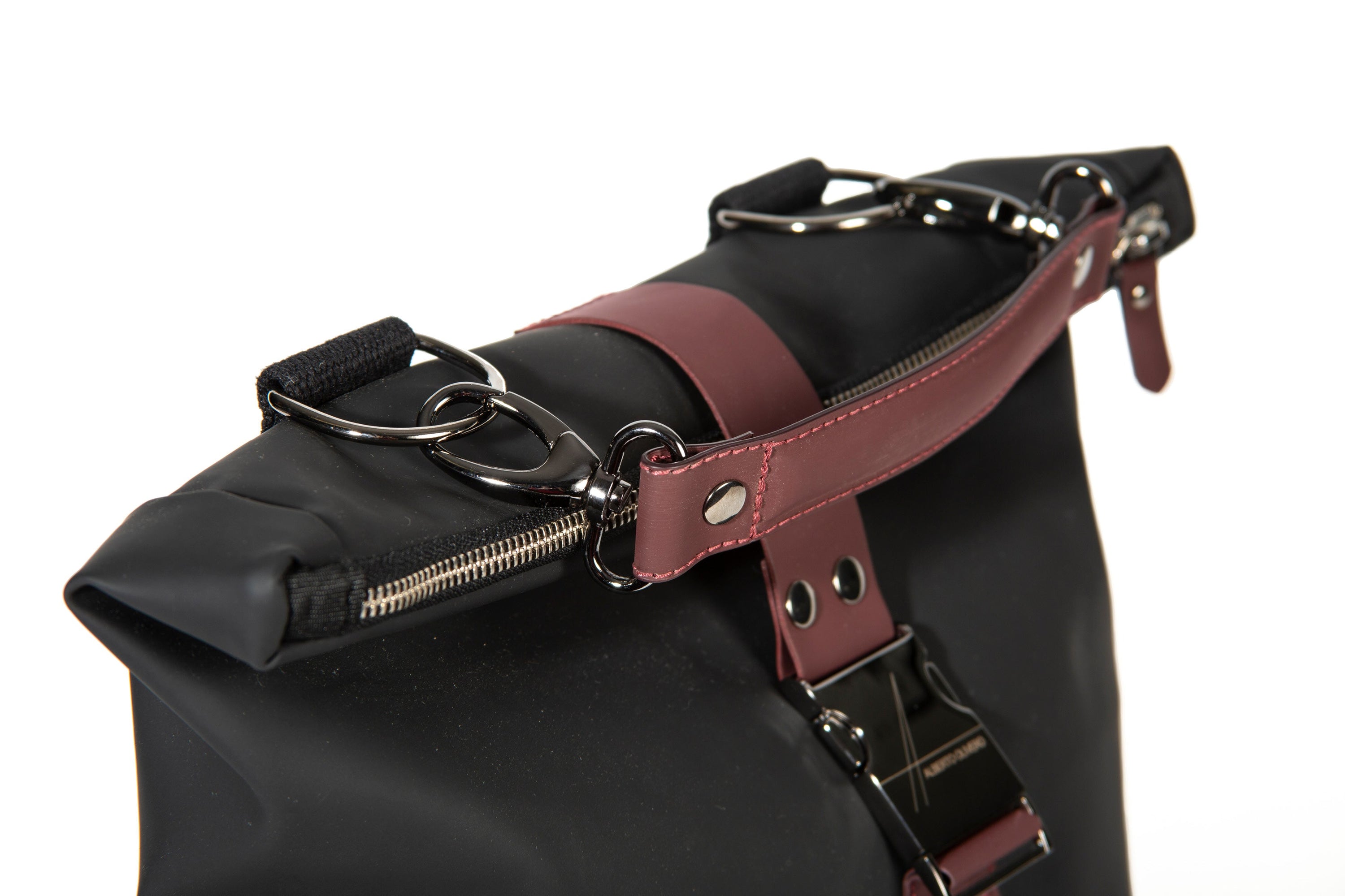 Detail shot of the exterior of the HADLEY Waterproof Backpack, designed by Italian designer Alberto Olivero, featuring handle and strap in bordeaux and solid gunmetal metal hooks