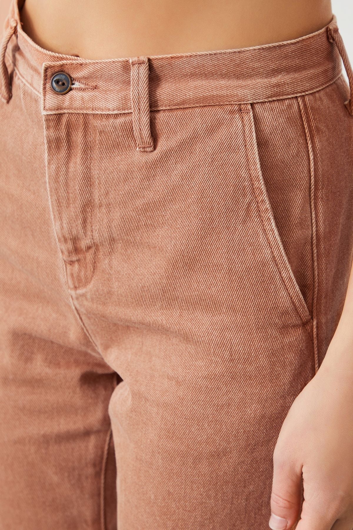 Detailed view of the slant pockets on the terracotta chino pants